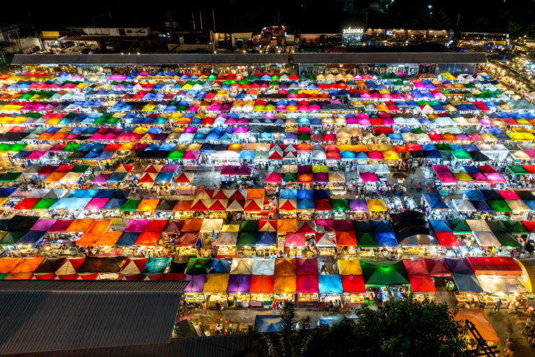 The Rot Fai night market in Bangkok, glows at night.