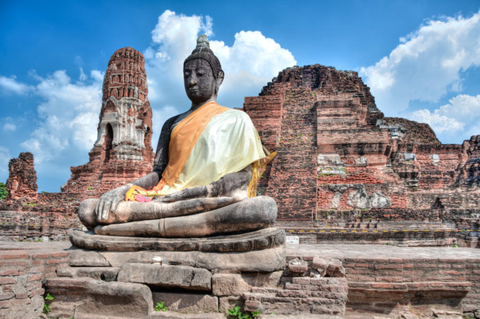 Photo of a Buddha statue, with a silk sash on it, by Ian Robert Knight.